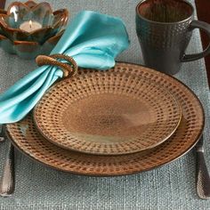 the place setting is set with silverware and blue napkins, along with a candle