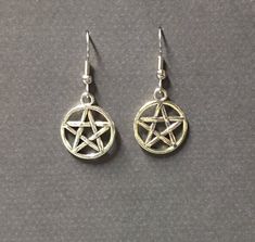 Handmade silver plated pentagram charm earring. A classic for every dark lady. Choose your metal type ear hook and I will make one just for you. Product details Pentagram charm is silver plated; Your choice of ear hook, sterling silver or silver plated. nickel free 1 1/2 inches long total VISIT MY SHOPS HERE * http://www.etsy.com/shop/HappyCatHouse * http://www.Etsy.com/shop/AnEnchantingCreature CONNECT * http://www.facebook.com/EnchantingCreature * https://instagram.com/enchantingcreature * htt Gothic Star-shaped Metal Earrings, Gothic Star Shaped Metal Earrings, Gothic Silver Star Earrings, Silver Star Gothic Earrings, Silver Witchy Earrings, Silver Witchy Pierced Earrings, Pentagram Earrings, Tiny Gold Earrings, Blush Earrings