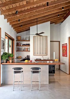 a kitchen with two stools next to an island