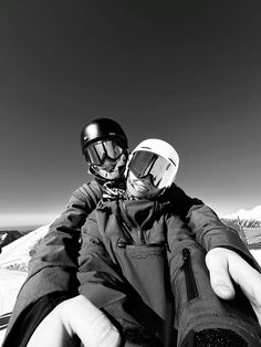 black and white photograph of two people in ski gear, one holding the other's hand