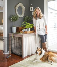 a woman standing next to a brown and white dog