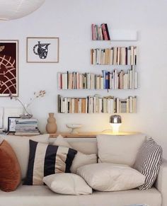 a living room filled with lots of furniture and bookshelves on top of it