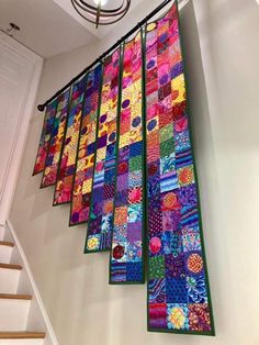 a colorful quilt hanging from the side of a stair case