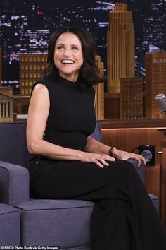 a woman sitting on top of a couch in front of a microphone