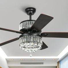 a ceiling fan with crystal chandelier hanging from it's blades in a living room