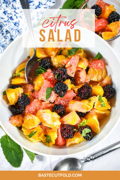 a white bowl filled with fruit salad next to a spoon