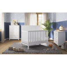 a baby's room with blue walls and white furniture