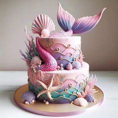 there is a cake decorated with mermaids and seashells