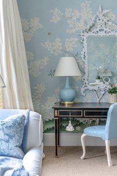 a blue chair and table in a room with a mirror on the wall behind it