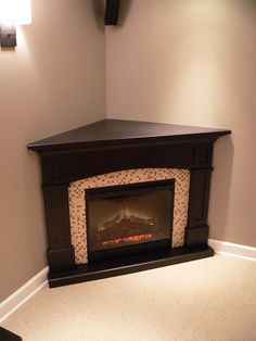 an empty room with a fire place in the corner and carpet on the floor next to it