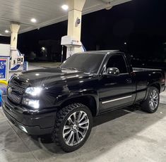 a black truck parked in front of a gas station