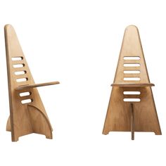 two wooden chairs sitting next to each other on top of a white surface with holes in them