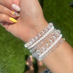 Adorn your arms with this stunning combination of white, crystal and gold-toned bracelets. Crafted to evoke a timeless elegance, these precious accessories are the perfect blend of minimalist sophistication and classic luxury. Material :* 4mm gold plated beads * charms * crystal beads *4mm matte beads • Bracelets are custom-crafted according to size; if the desired size isn't listed below, please contact me for assistance. • Processing Time is an estimated 3-5 business days (does not include wee Everyday White Cubic Zirconia Jewelry, White Party Bracelets With Rhinestones, White Rhinestone Bracelets For Party, Everyday White Pearl Stretch Bracelet, White Pearl Jewelry With Faceted Beads, Elegant Faceted Crystal Beaded Bracelets, White Faceted Beads Crystal Bracelet, White Crystal Bracelet With Faceted Beads, White Pearl Jewelry With Rhinestones