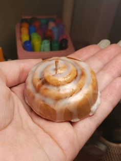 a hand holding a donut with icing on it