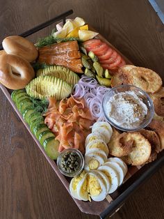 an assortment of food on a platter with dipping sauces and pretzels