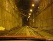 a car driving down a tunnel with lights on at the end of it's lane