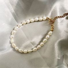 Adorn your wrist with timeless elegance in our Classic Dainty Pearl Bracelet. Delicately crafted, this bracelet features lustrous pearls, creating a graceful and sophisticated accessory. The understated design adds a touch of refinement to any ensemble, making it perfect for both casual and formal occasions. Embrace the enduring beauty of pearls with this classic bracelet, a symbol of timeless style and grace. Classic Adjustable Chain Bracelet With Pearl Charm, Pearl Bracelet With Pearl Charm For Formal Occasions, Elegant Adjustable Pearl Chain Bracelet, Formal Adjustable Pearl Chain Bracelet, Elegant Adjustable Bracelet With Pearl Drop, Classic Pearl Charm Bangle Bracelet, Classic White Chain Bracelet With Pearl Drop, Pearl Chain Bangle Bracelets, Pearl Bangle Bracelet With Pearl Chain