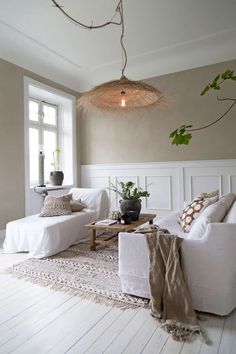 a living room with two white couches and a coffee table