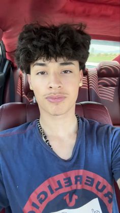 a young man sitting in the back seat of a car