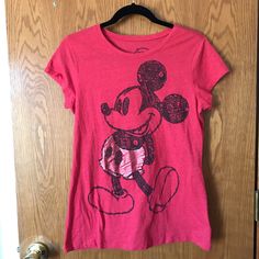 a pink shirt with a mickey mouse on it