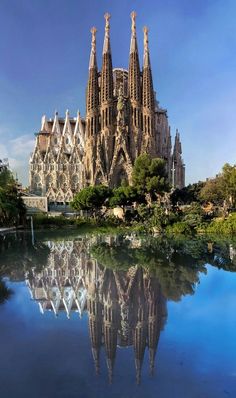 the cathedral is very tall and has many spires on it's sides, reflecting in the water