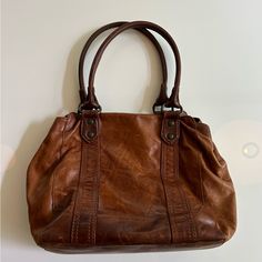 Perfectly Worn Well Loved Condition With Original Frye Protective Bag. - Interior Pockets - Antique Pull Up Leather - Italian Leather - Antique Metal Hardware -12" Height - 13" Width - 9" Strap Drop - 1 Interior Zip Pocket, Double Slip Pockets, 1 Divider With Zip Pocket - Magnetic Snap Closure - Imported Has 2 Small Spots On The Outside Side Visible In Photo. Perfect Condition Inside. Cognac Leather Bag With Zipper Pocket, Frye Purses And Handbags, Brown Vegetable Tanned Leather Tote Shoulder Bag, Frye Handbags, Vintage Brown Vegetable Tanned Leather Bag, Frye Bags, Antique Metal, Pull Ups, Womens Tote