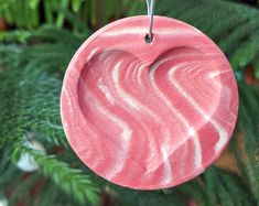 a pink ornament hanging from a christmas tree