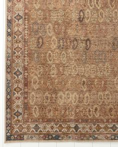 an antique rug with many different colors and patterns on the carpet is displayed in front of a white wall