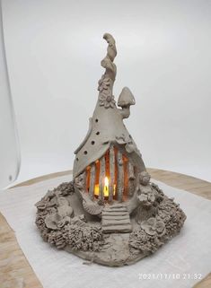 a small house made out of clay and lit candles