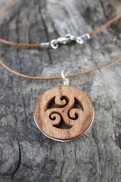 "This beautiful and unique hand-carved Triskelion pendant will be made for you, or a loved one, in my studio on the West of Ireland. Encircled with a Sterling silver ring into a side groove, this intricate carving features a piece of elm. Considered one of the sacred trees in the Celtic world, elm has often been associated with Mother and Earth Goddesses. In rural Ireland the elm tree was said to possess magical properties and was considered to be the home of the fairies. Found inscribed on mega Symbolic Carved Brown Jewelry, Natural Carved Adjustable Jewelry, Nature-inspired Carved Round Pendant Jewelry, Natural Color Carved Adjustable Jewelry, Brown Spiral Jewelry As A Gift, Brown Spiral Necklace For Gifts, Nature-inspired Carved Natural Jewelry, Rural Ireland, Intricate Carving