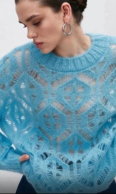 a woman is wearing a blue sweater with an openwork design on the front and back