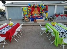 an outdoor party set up with tables, chairs and balloons in the shape of cows