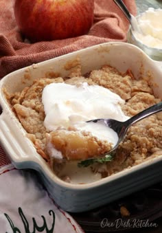 an apple crisp in a baking dish with ice cream on top and apples in the background