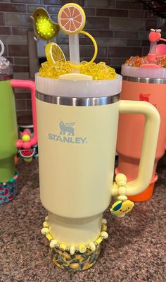 there is a cup with some fruit in it on top of the counter next to other cups