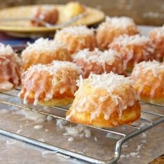 several donuts with icing and sprinkles on a cooling rack