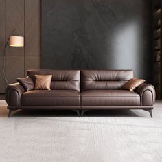 a brown leather couch sitting in a living room next to a lamp