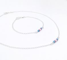 "Handmade sterling silver jewellery set. Necklace och bracelet. Dainty acrylic beads making up the transgender pride flag. Delicate silver chain. Sizing instructions: Necklace: Order at least 2.5 cm (1\") longer than the intended wearers neck for a tight fit. Longer for a looser fit. Bracelet: Order 1.5 cm (1/2\") longer than the intended wearers wrist for a proper fit. Stand alone bracelet: https://www.etsy.com/listing/1012672163 Stand alone necklace: https://www.etsy.com/listing/998700534 This Minimalist Silver Beads Jewelry As Gift, Minimalist Silver Beads Jewelry Gift, Sterling Silver Beaded Jewelry, Gift Sterling Silver Necklace With Spacer Beads, Minimalist Silver Beaded Jewelry As A Gift, Sterling Silver Necklace With Spacer Beads As Gift, White Sterling Silver Jewelry With Spacer Beads, Dainty Sterling Silver Jewelry With Spacer Beads, Dainty Silver Jewelry With Polished Beads