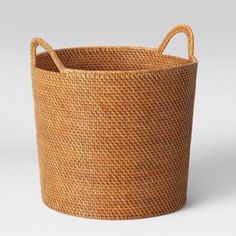 a large woven basket with handles is shown in this image, it's brown