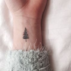 a small pine tree tattoo on the wrist