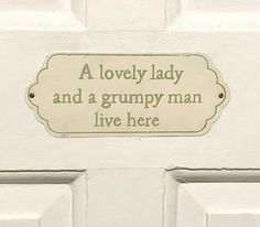 a white door with a sign that says a lovely lady and a grumpy man live here