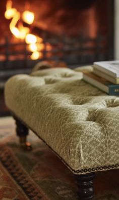 a bench with books on it in front of a fire place