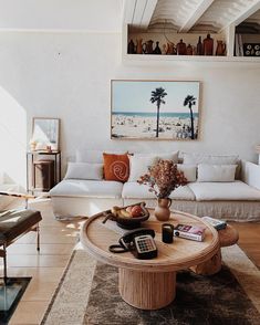 a living room filled with furniture and a coffee table in front of a painting on the wall