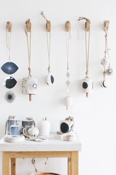 a wooden table topped with lots of different items next to a wall mounted on hooks