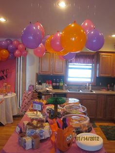 a birthday party with balloons and food on the table