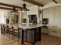 a large kitchen with an island in the middle and lots of chairs on the side