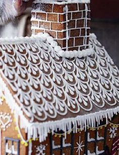 a close up of a gingerbread house with icing on it