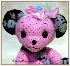 a pink teddy bear with polka dots and a bow