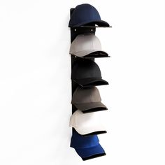 a baseball hat hanging on the side of a wall next to a ball cap holder