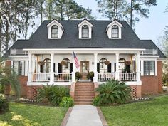 a white house with black roof and porch