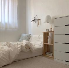 a bedroom with a bed, dresser and window